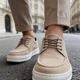 Beige suede lace-up shoes with stitched toe and white sole, close angle