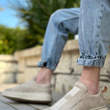Beige suede slip-on sneakers, rear view with cushioned collar and white sole.