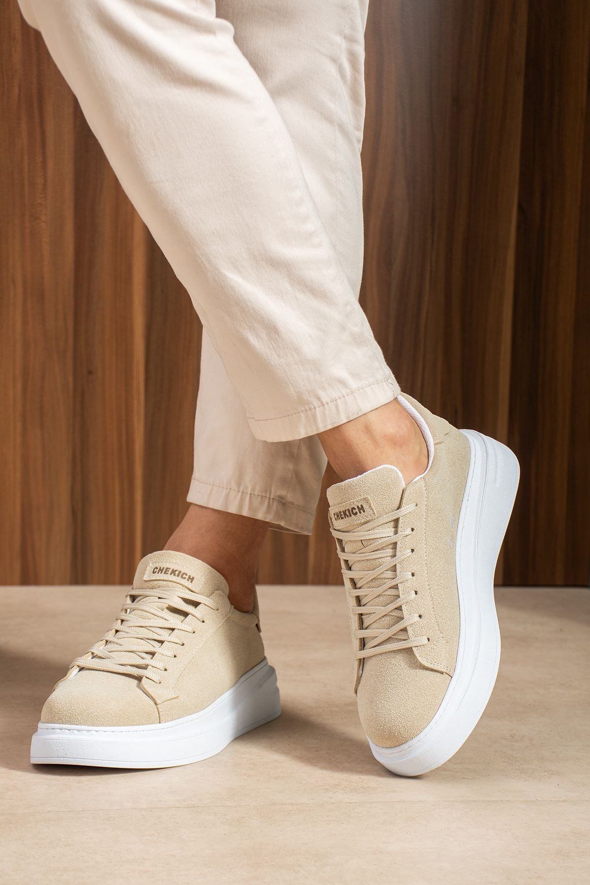 Beige suede low-top sneakers with white rubber sole and lace-up front