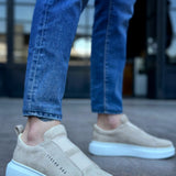 Beige suede slip-on sneakers with light blue sole and side logo detail