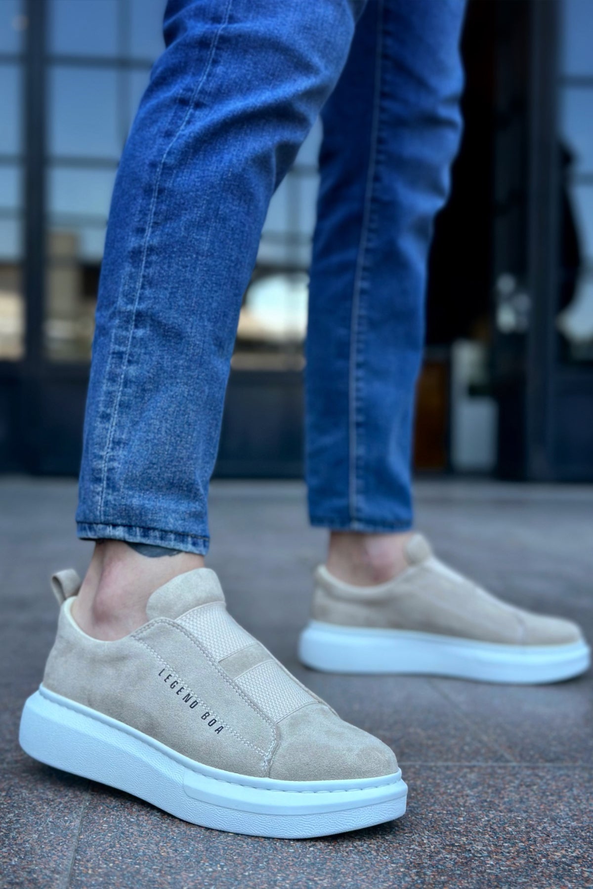 Beige suede slip-on sneakers with light blue sole and side logo detail