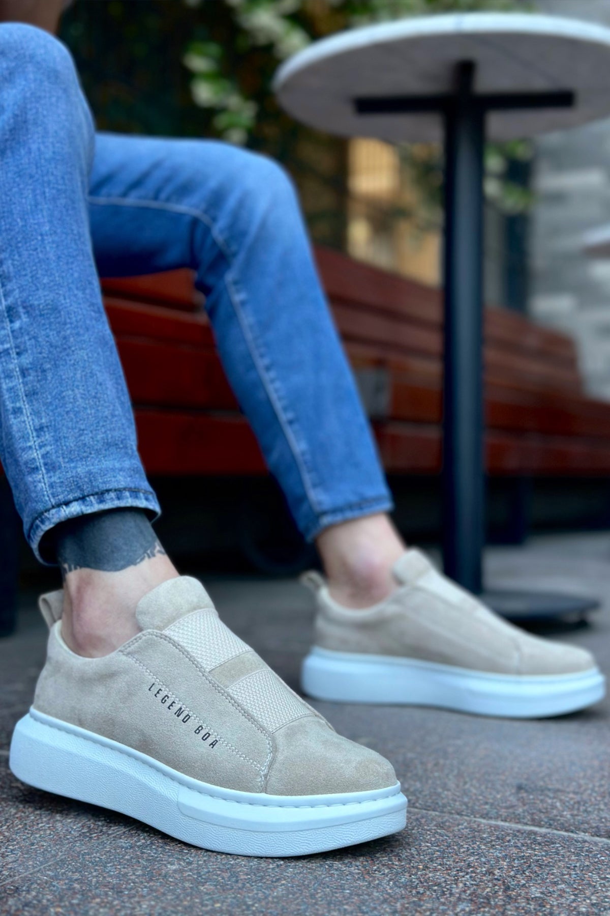 Beige suede slip-on sneakers with light blue rubber sole and side logo