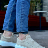 Beige suede slip-on sneakers with light blue sole and rear pull-tab