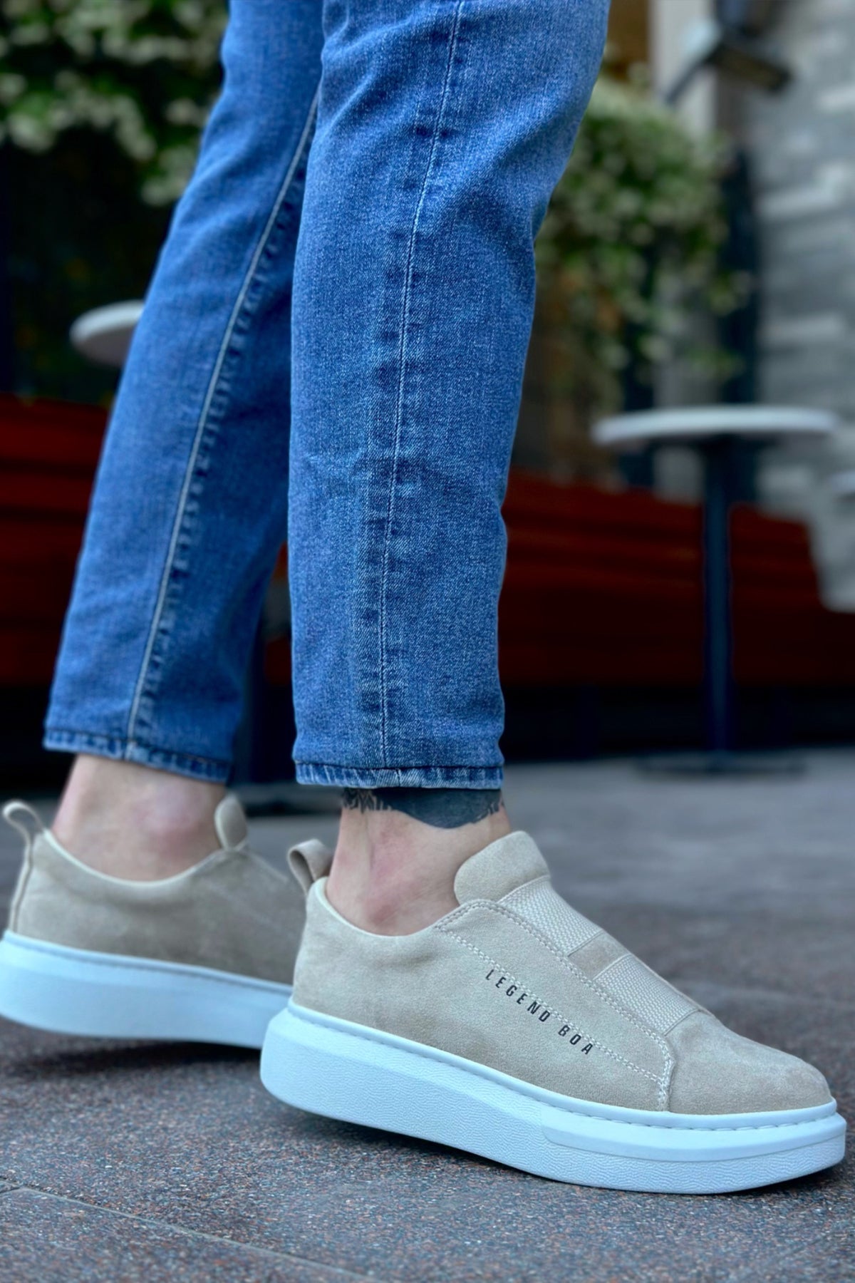 Beige suede slip-on sneakers with light blue sole and rear pull-tab