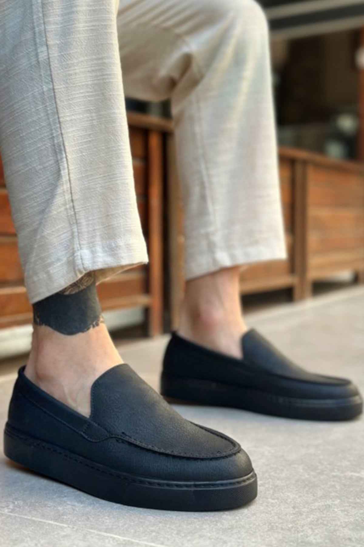 Men's black slip-on loafers with moc-toe seam detail and flat sole