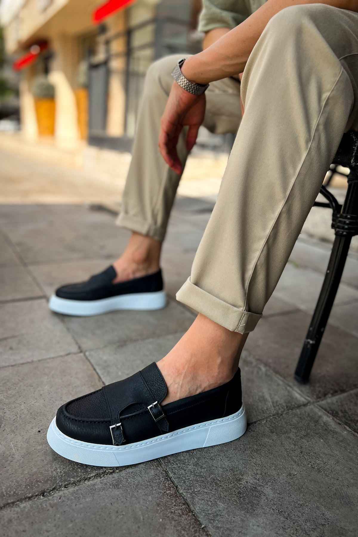 Men's black leather-look loafers with buckle strap and light blue rubber sole
