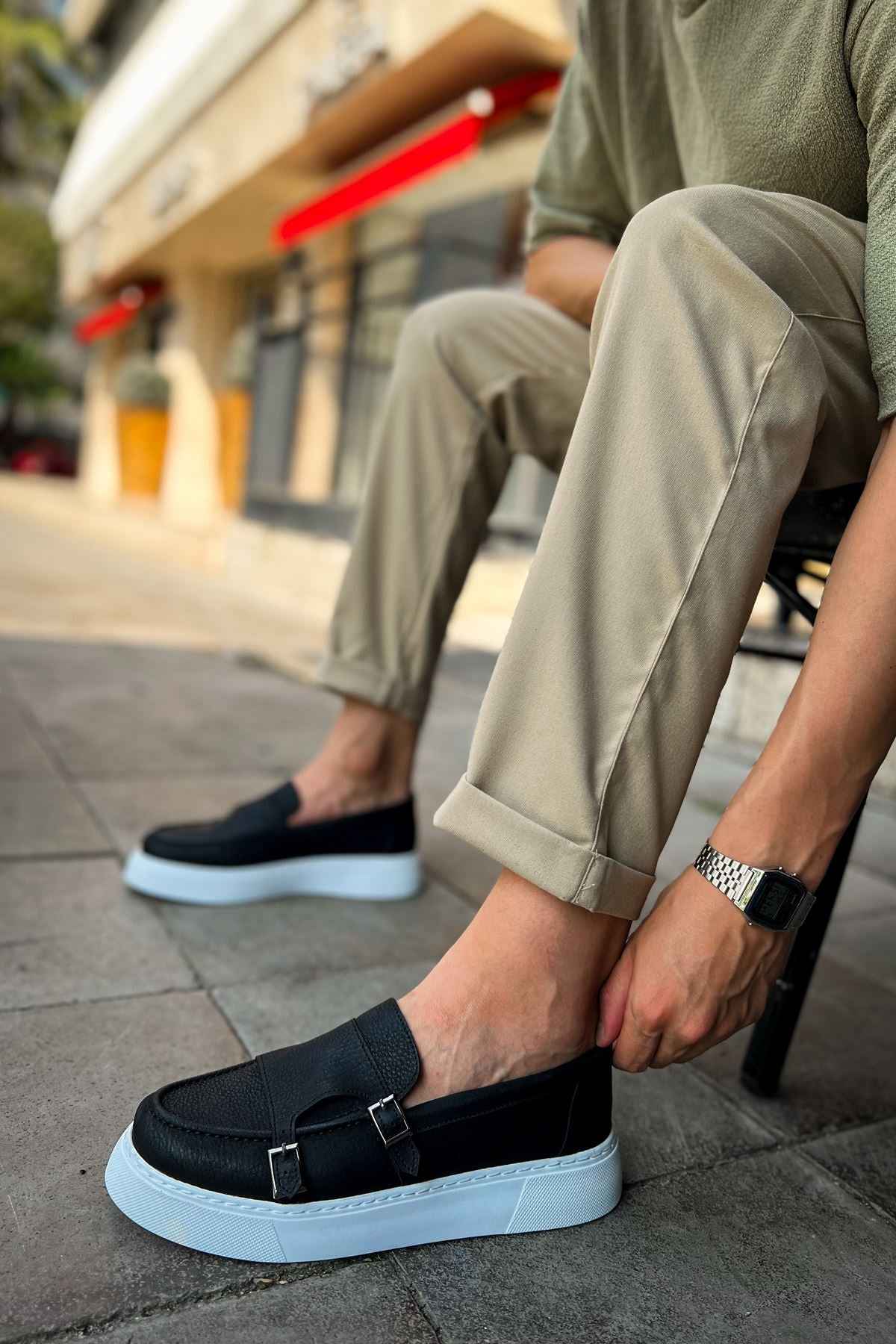 Black loafers with buckle strap and light blue sole, side angle view