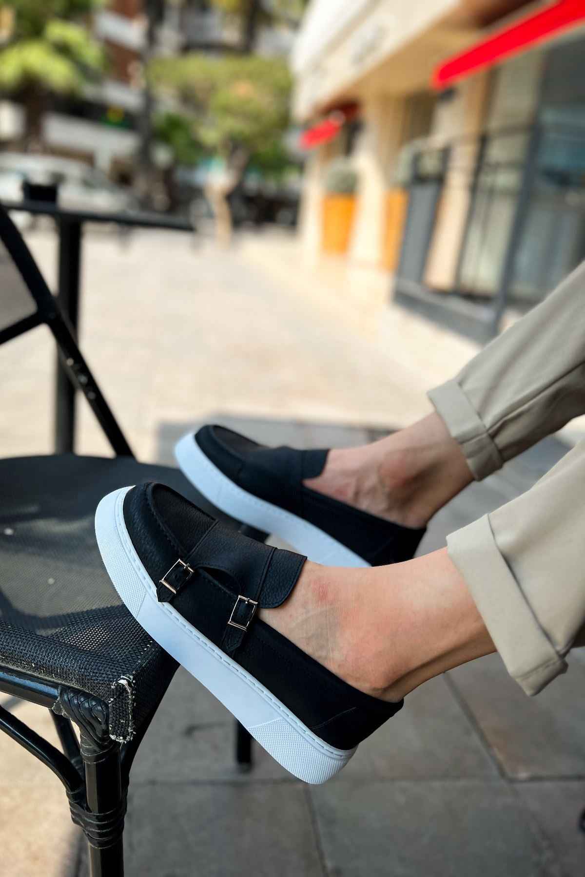 Black loafers with two-buckle strap and light blue sole, close-up top view