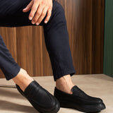 Men's black slip-on loafers, stitched top strap and smooth low sole, side view