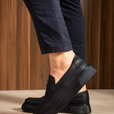 Men's black loafers with stitched upper, low sole, and back heel detail