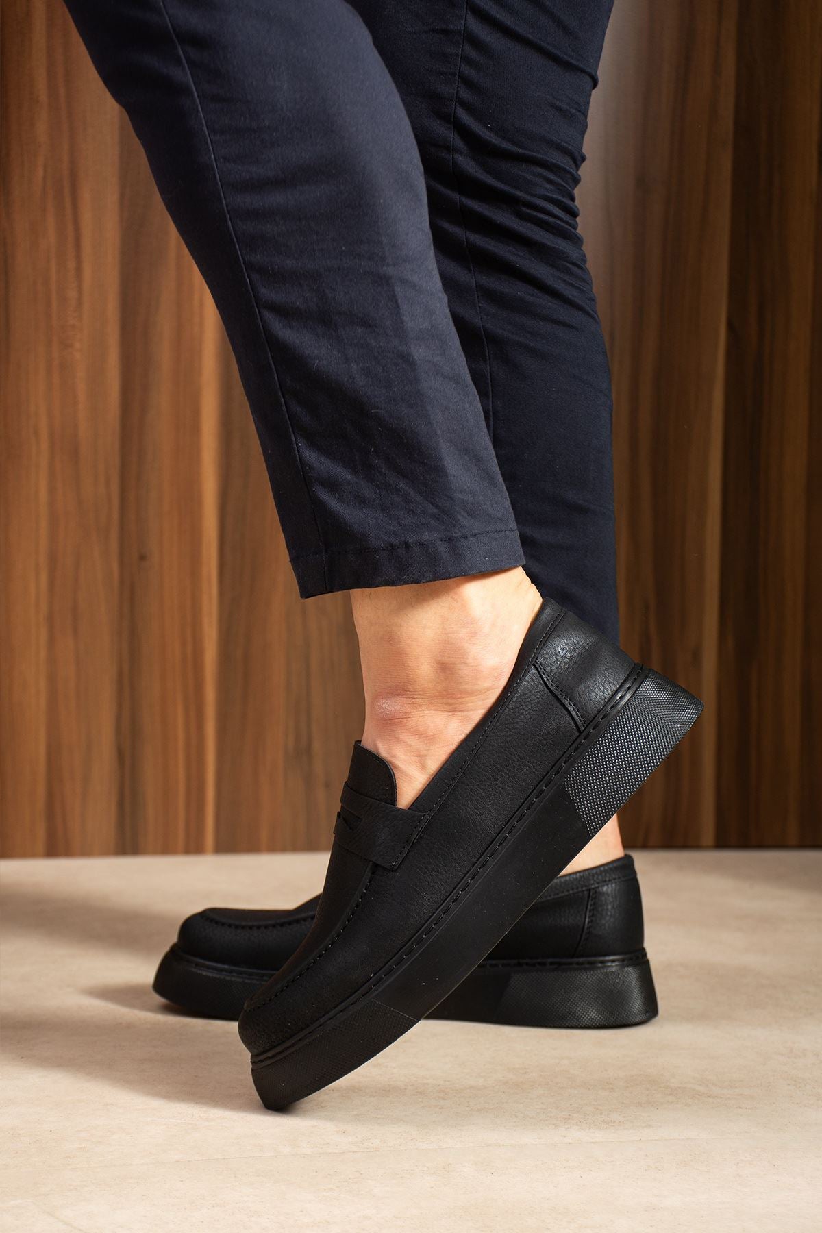 Men's black loafers with stitched upper, low sole, and back heel detail