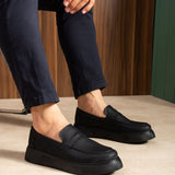 Men's black slip-on loafers with stitched vamp and low-profile sole, angled view
