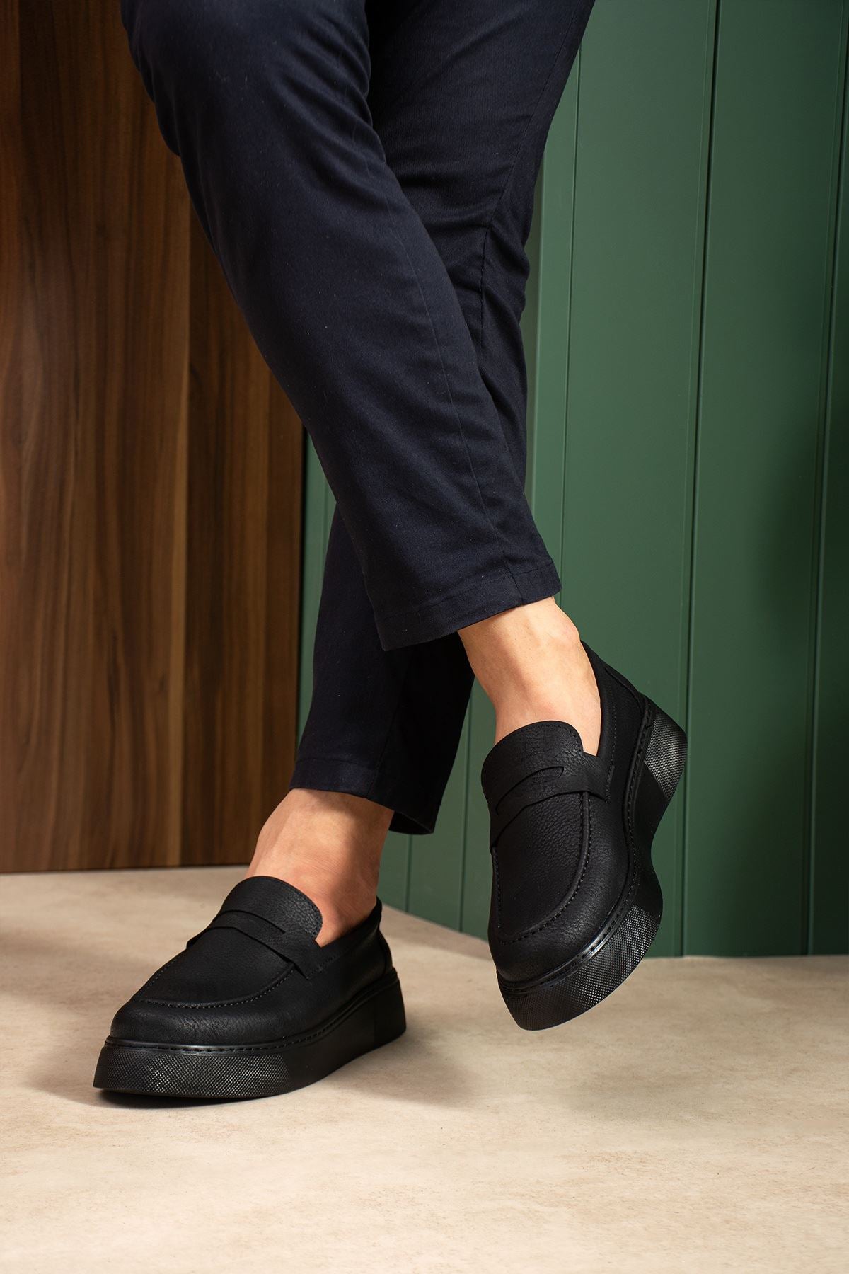 Men's black slip-on loafers with smooth upper and low sole, side close-up