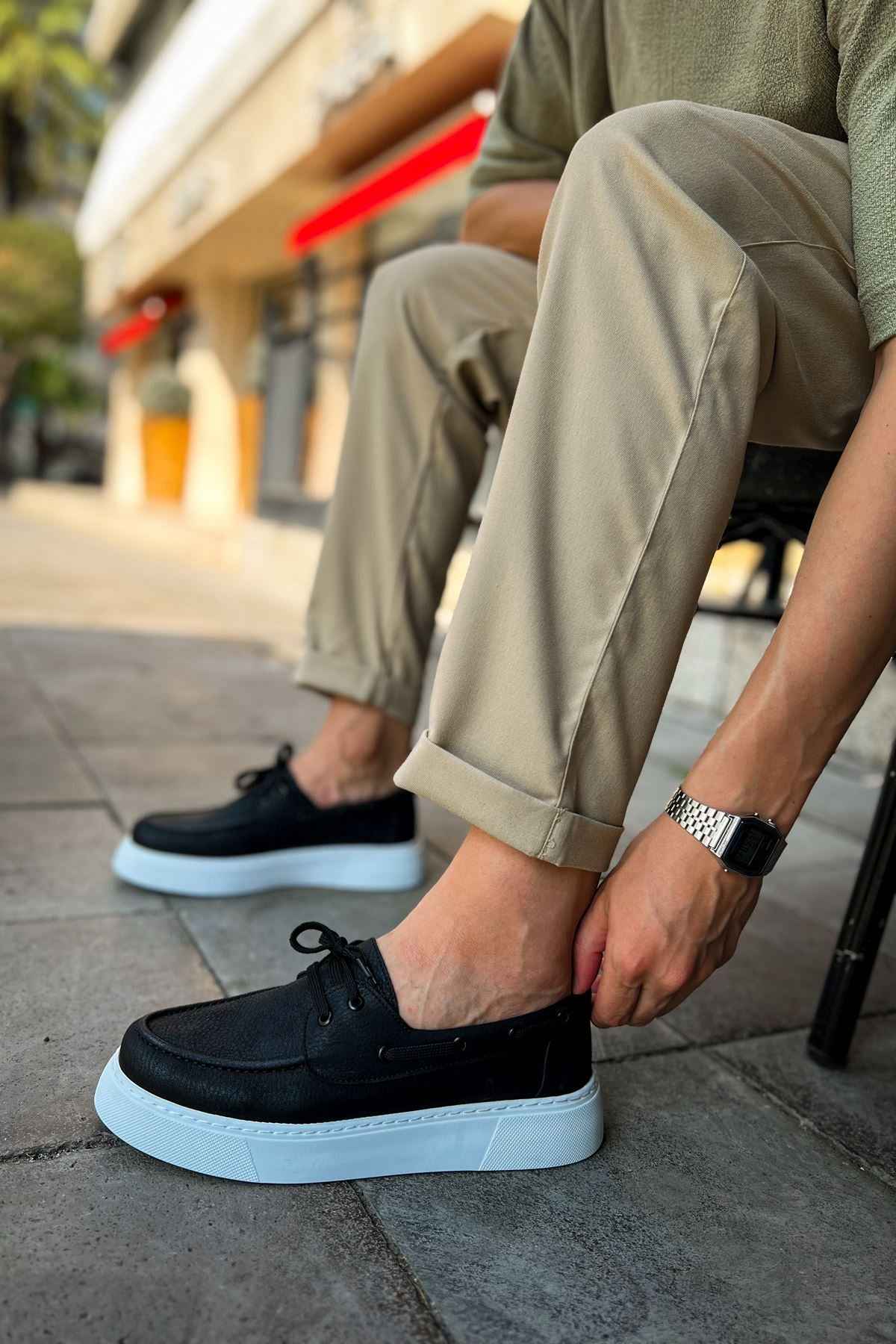 Men's casual black lace-up shoes with light blue rubber sole, side profile