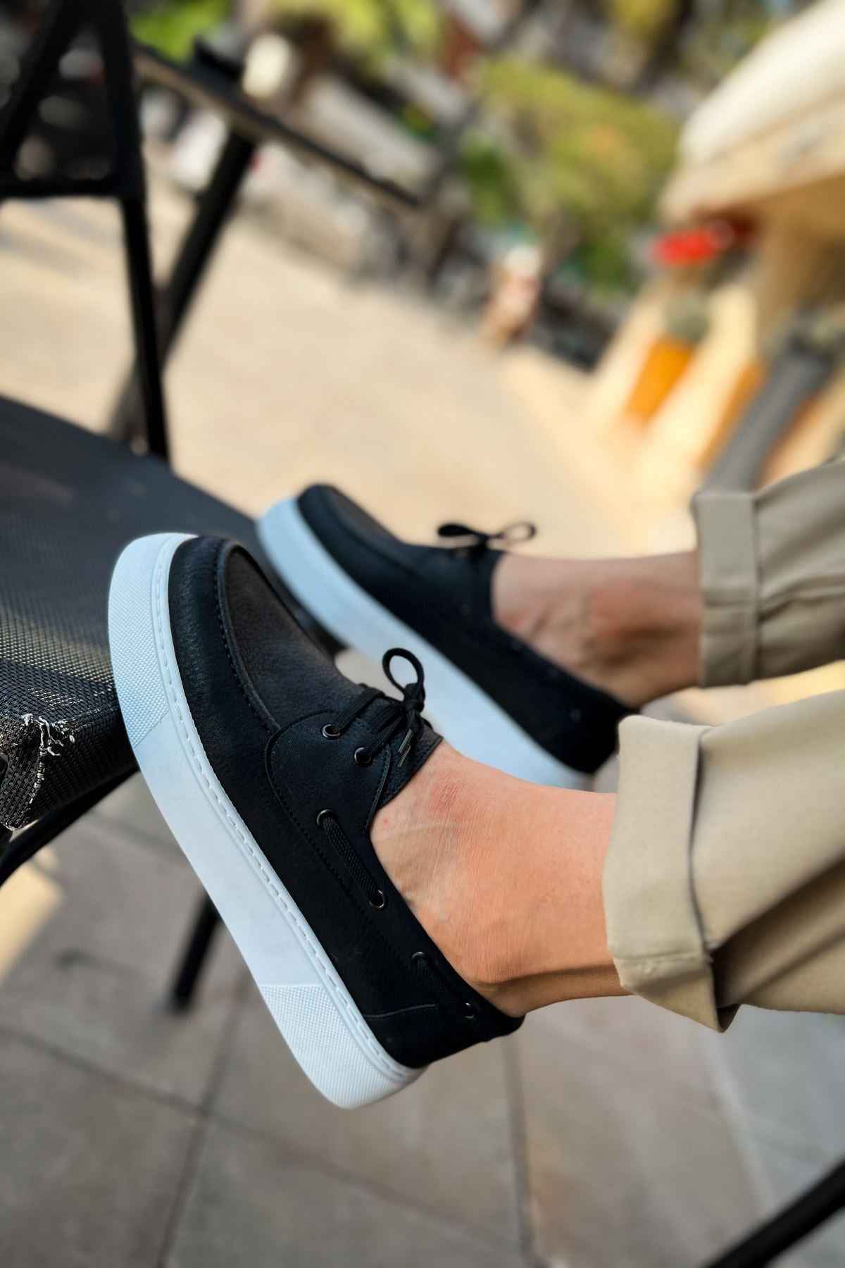 Men's casual black lace-up sneakers, close-up front with light blue sole