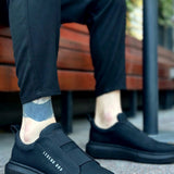 Men's casual dark sneakers, side view with elastic panel and cushioned sole