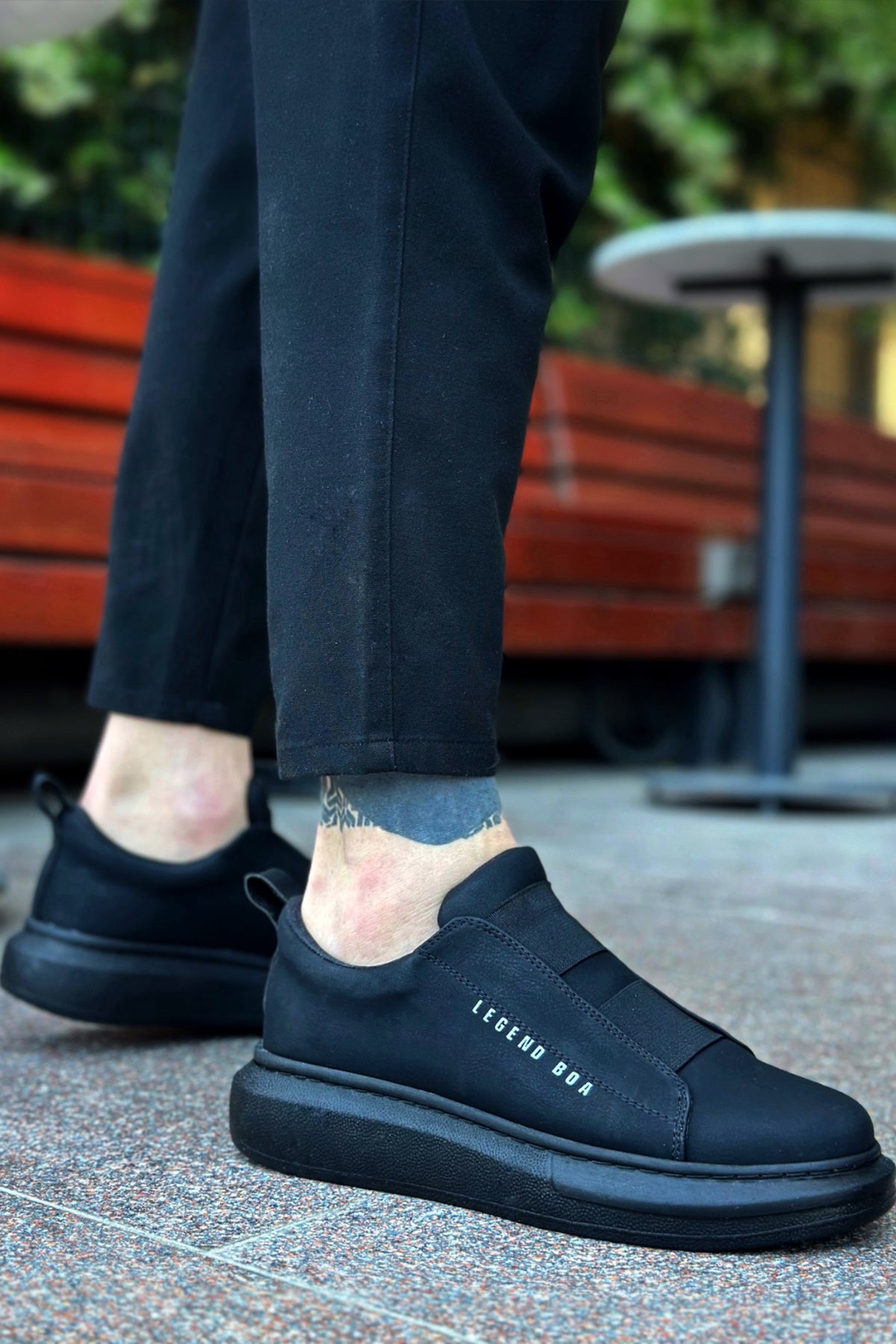 Men's casual dark low-top sneakers with side logo detail and thick rubber outsole