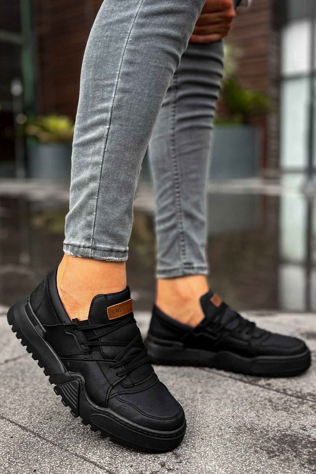 Men's black low-top sneakers with orange logo patch, hook-and-loop straps