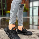 Men's black low-top sneakers, orange logo patch on the side, side view