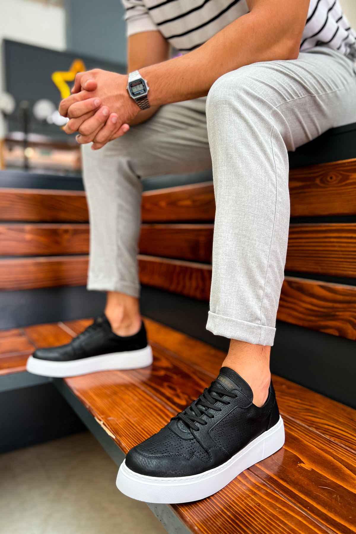 Men's black lace-up sneakers with white rubber sole, angled view