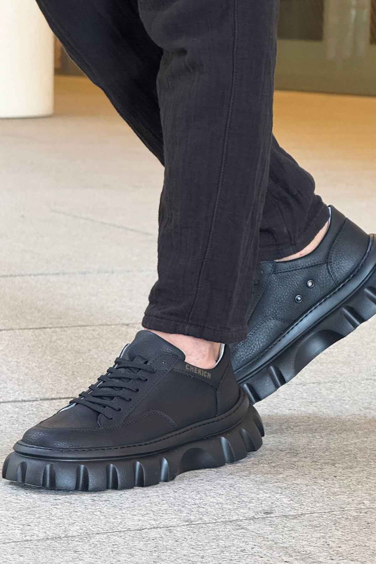 Men's casual black lace-up sneakers with textured sidewall and thick tread sole