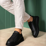 Black casual sneakers with wide side strap and thick rubber sole