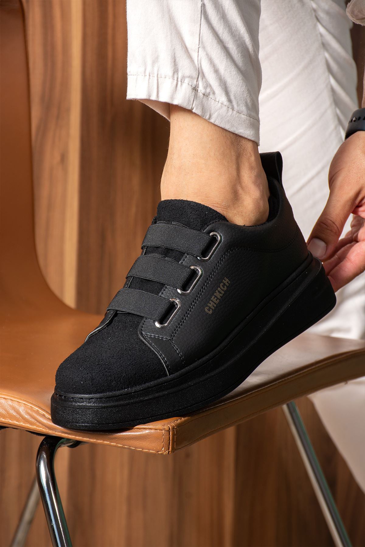 Black low-top sneakers with padded collar and hook-and-loop strap on the side
