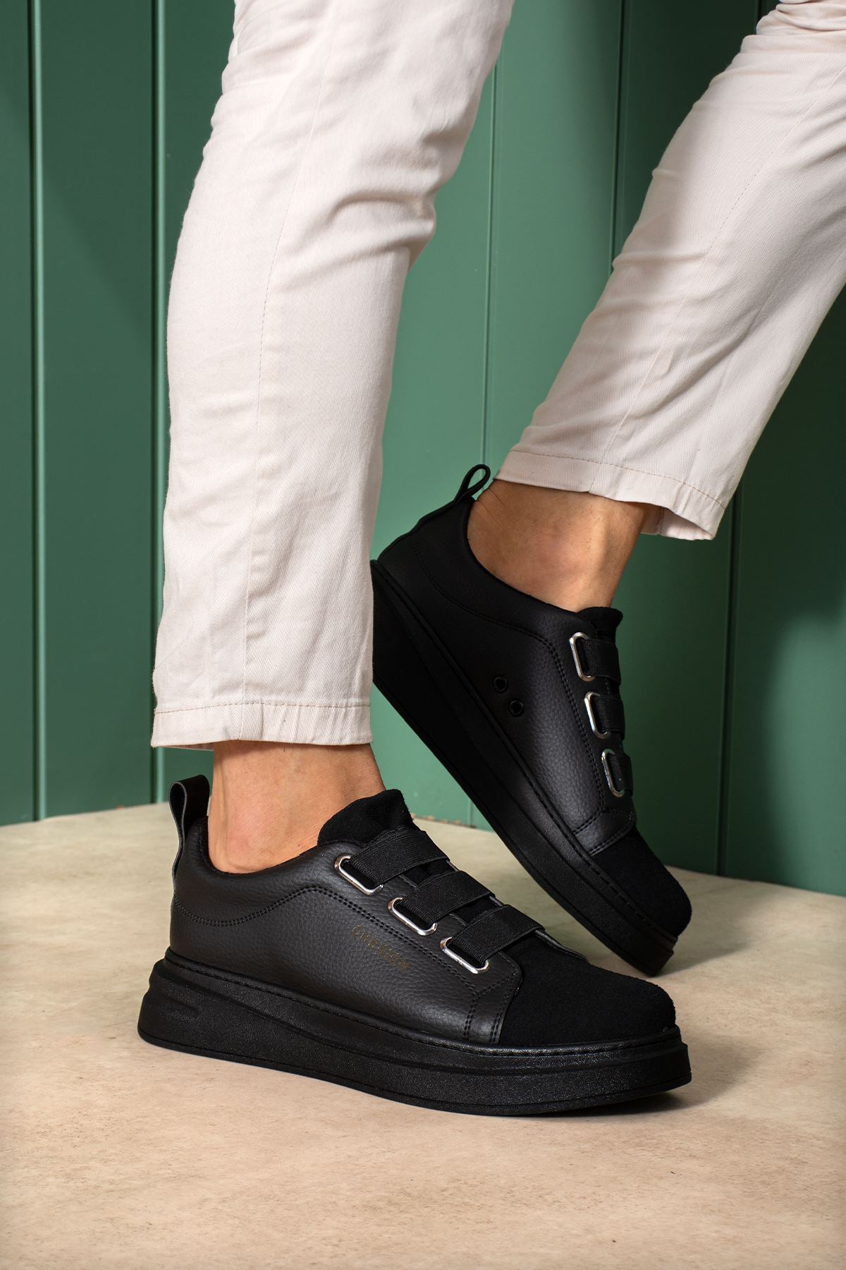 Pair of black low-top sneakers with front strap and cushioned sole
