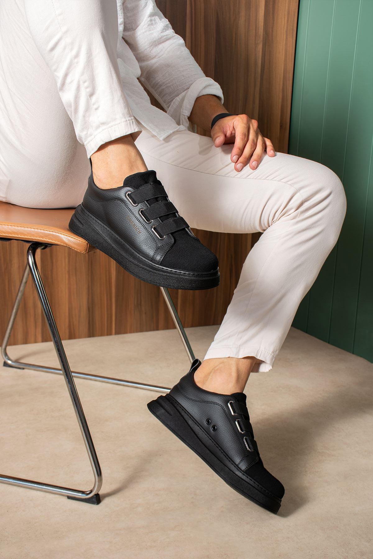 Black low-top sneakers with hook-and-loop strap and textured outsole