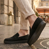 Men's black suede loafer with flexible slip-on fit, showing side tread