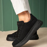 Men's black suede lace-up sneakers with thick rubber sole, side view.