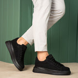 Men's black suede lace-up sneakers with black rubber sole, side view.