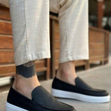 Men's casual black slip-on loafers with white soles and low profile