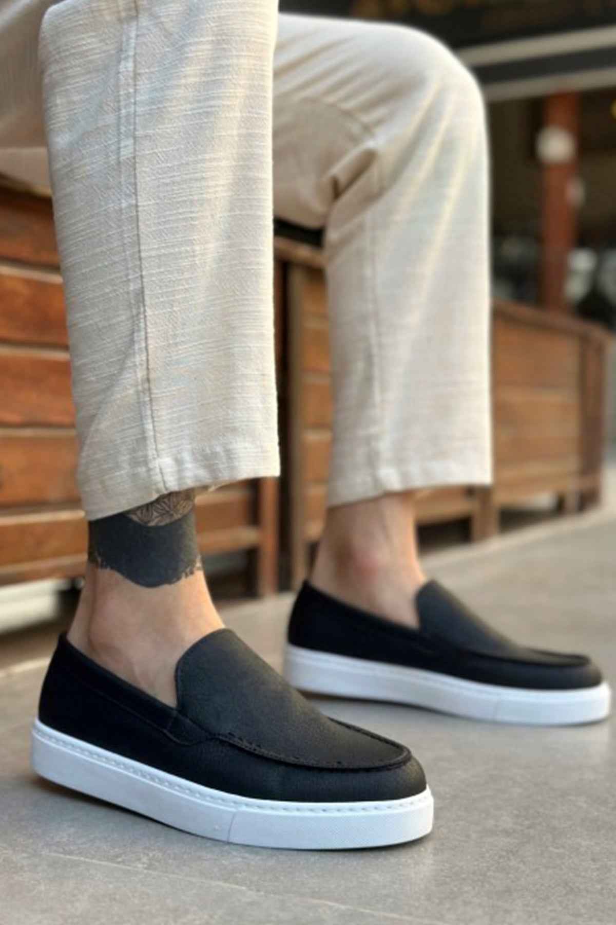 Men's casual black slip-on loafers with white soles and low profile