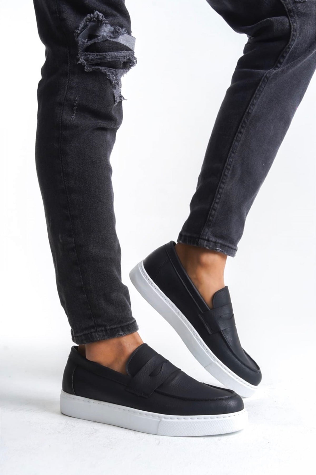 Men's black slip-on loafers with white rubber sole and smooth vamp