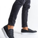 Men's black loafers with white sole, low-profile slip-on design and side stitching