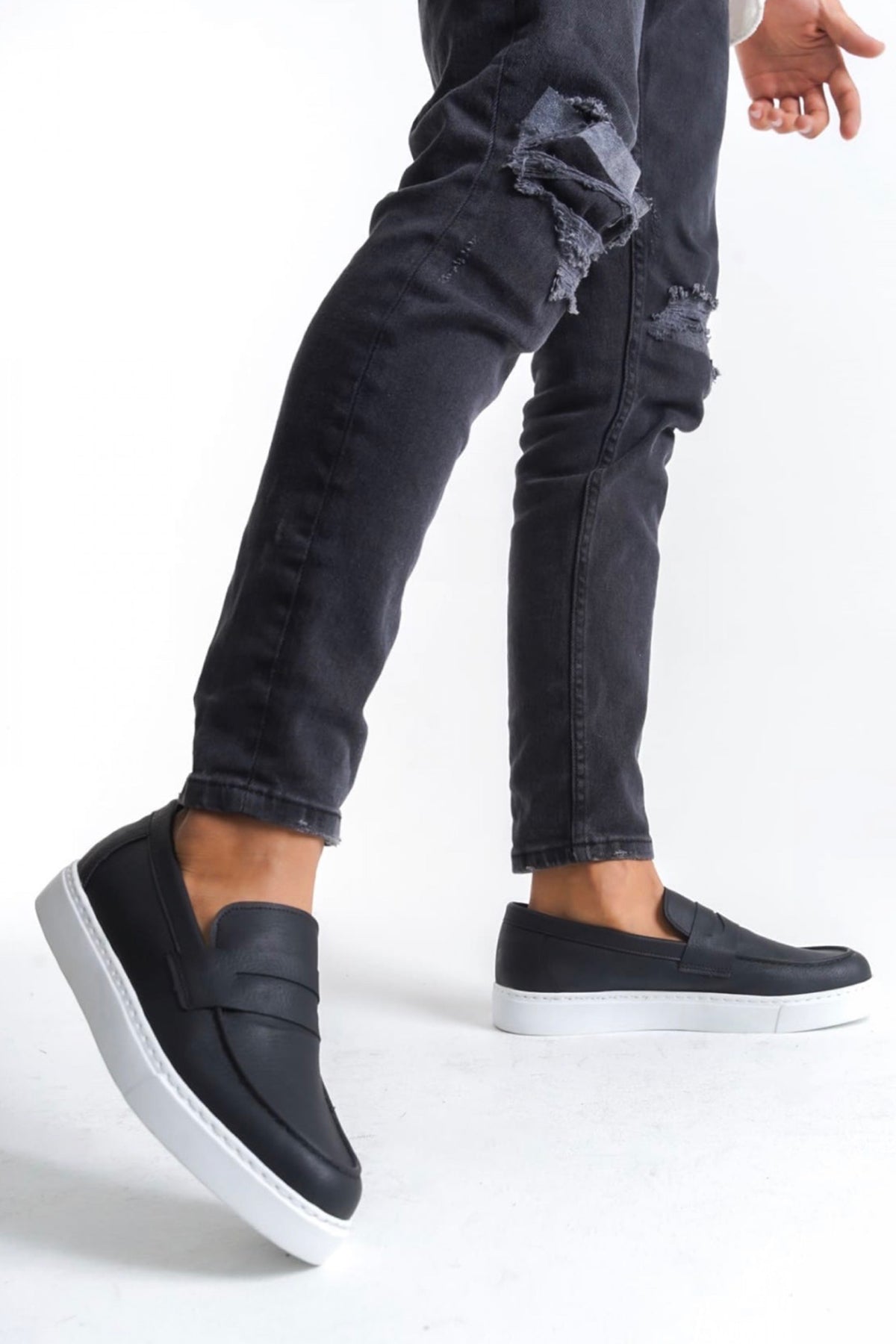 Men's black loafers with white sole, low-profile slip-on design and side stitching