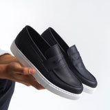 Men's black leather-look loafers with white sole and front strap detail