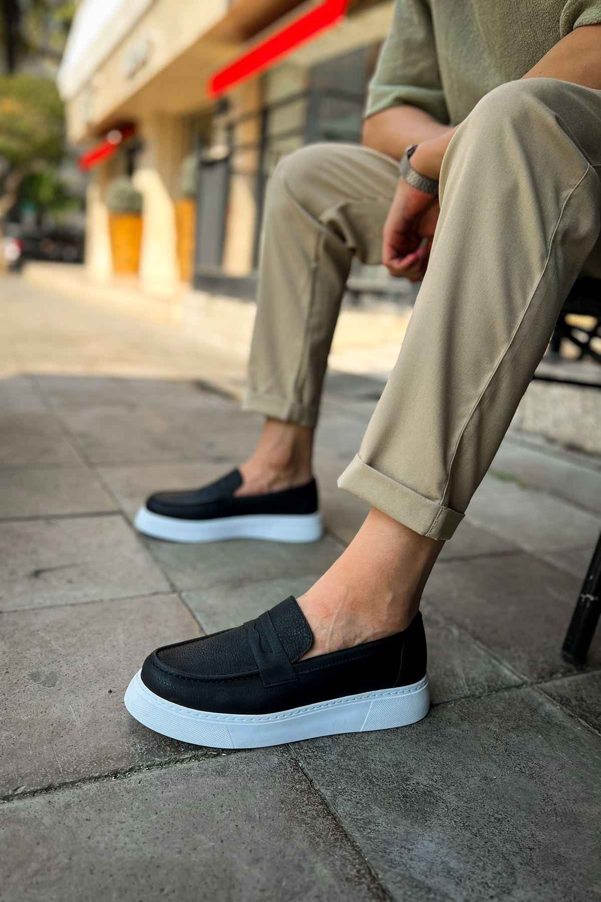 Men's black slip-on loafers with dark upper and white rubber sole