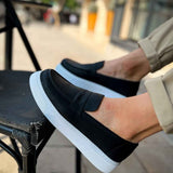 Men's black loafers with a wide band vamp and white rubber sole
