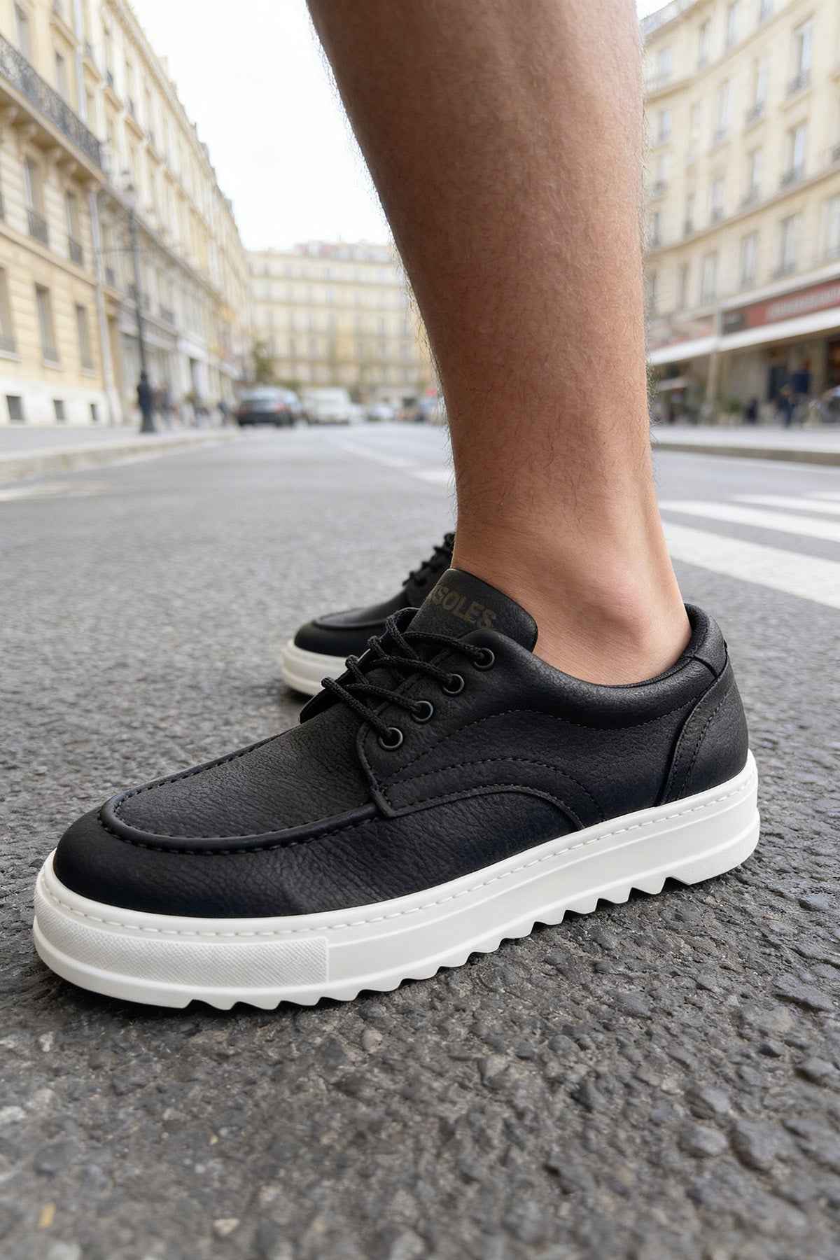 Men's black casual lace-up shoes with white sole, side close-up