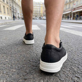 Men's black casual lace-up shoes with white rubber sole, rear view