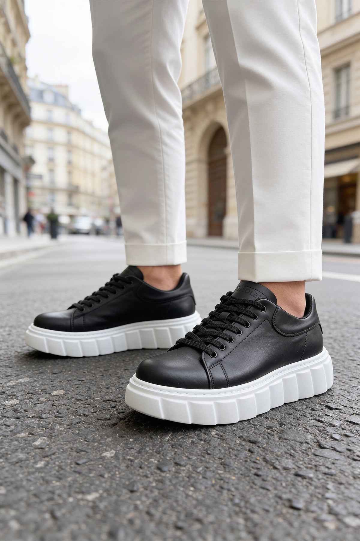 Black lace-up sneakers with white chunky sole and textured side panels