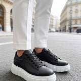 Black leather sneakers with white sole, side view, thick platform design