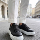 Black lace-up sneakers with white chunky soles, toe and lace detail