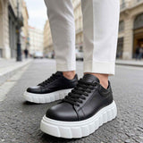 Black low-top sneakers with white thick soles and black lace-up closure
