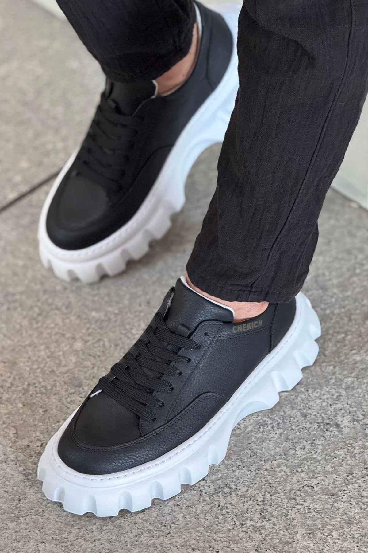 Black lace-up sneakers with thick white platform sole