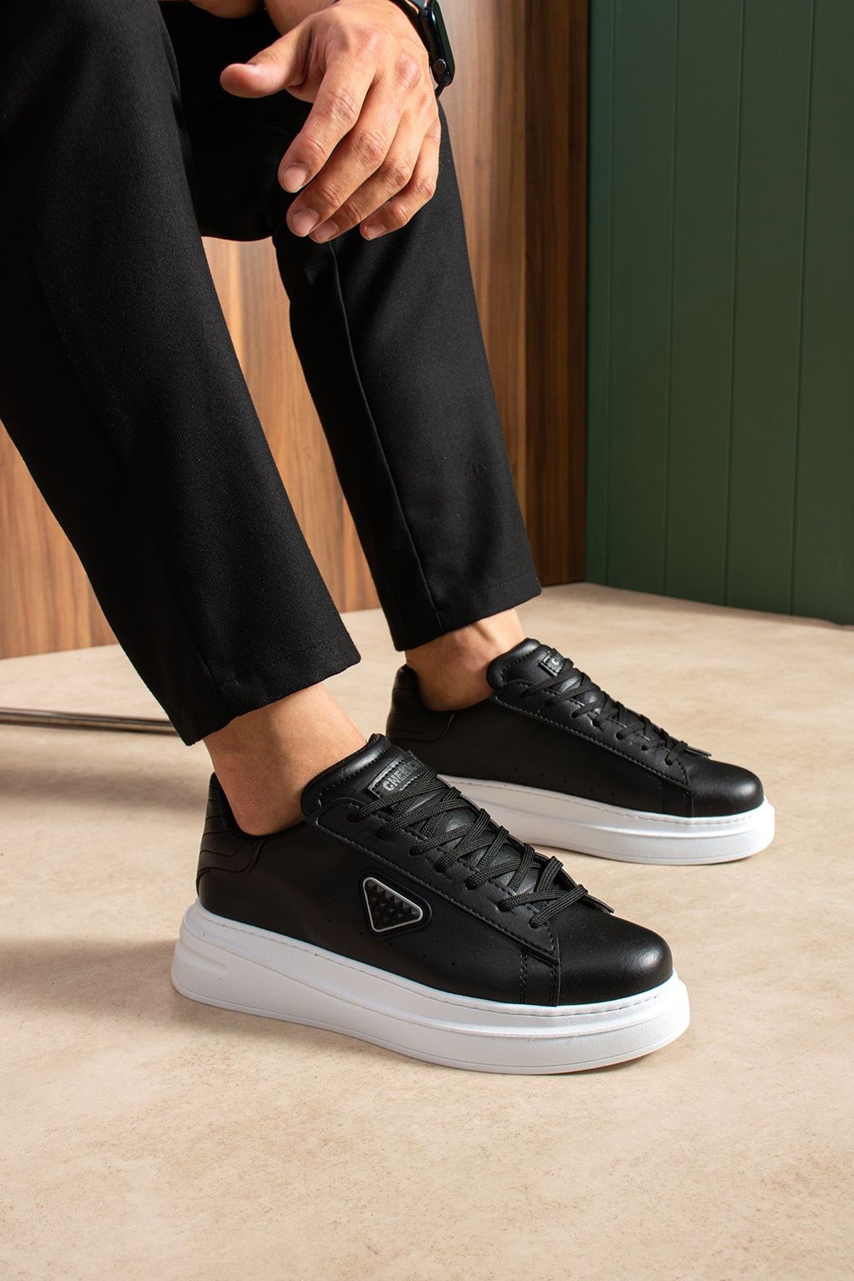 Black lace-up sneakers with white sole, side triangle logo detail