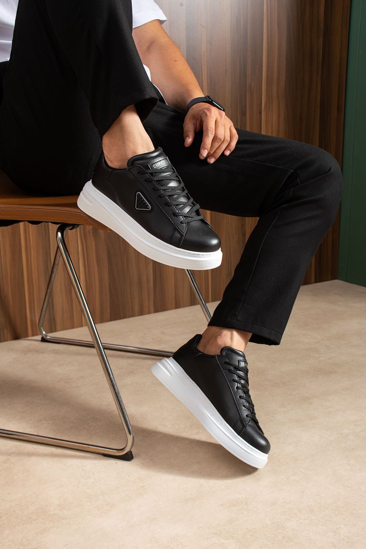 Black lace-up sneakers with white platform sole and side logo