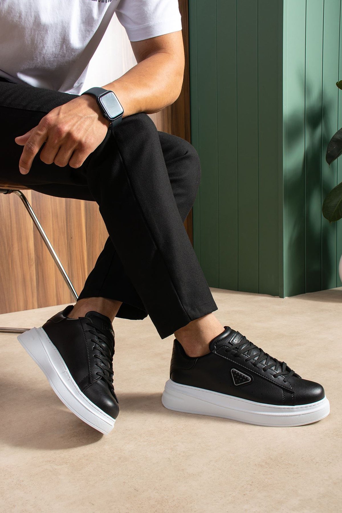 Black lace-up sneakers with white sole, side triangle logo